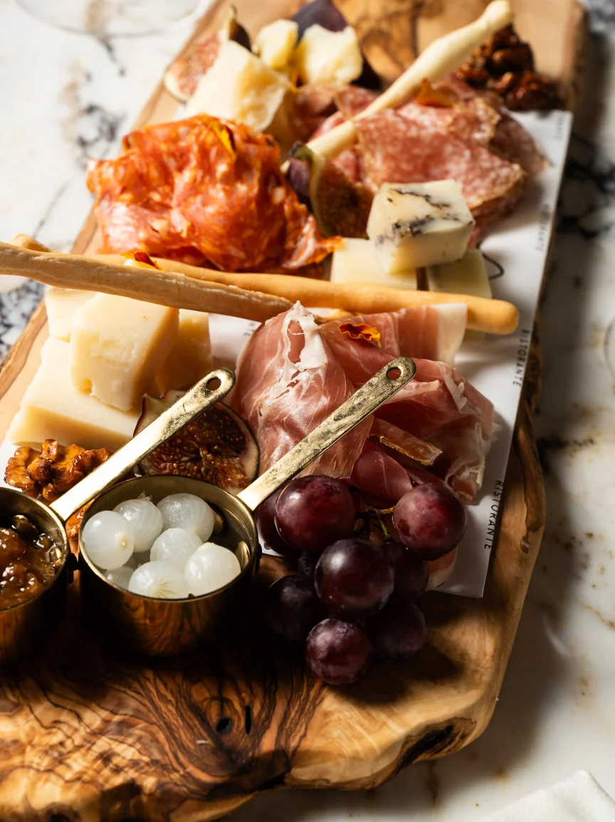 A charcuterie board: cured meats, cheeses, grapes and figs